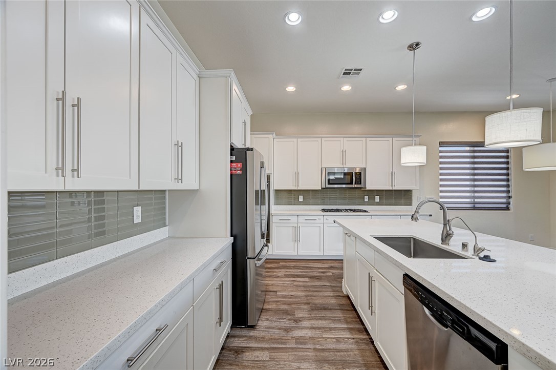 8197 Riley Love Street Las Vegas, NV 89139 - Photo 17 of 48 A well-appointed kitchen showcases contemporary white cabinetry, durable countertops, and sleek appliances.