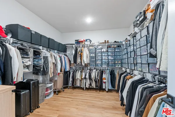 a view of walk in closet with clothes and shoes