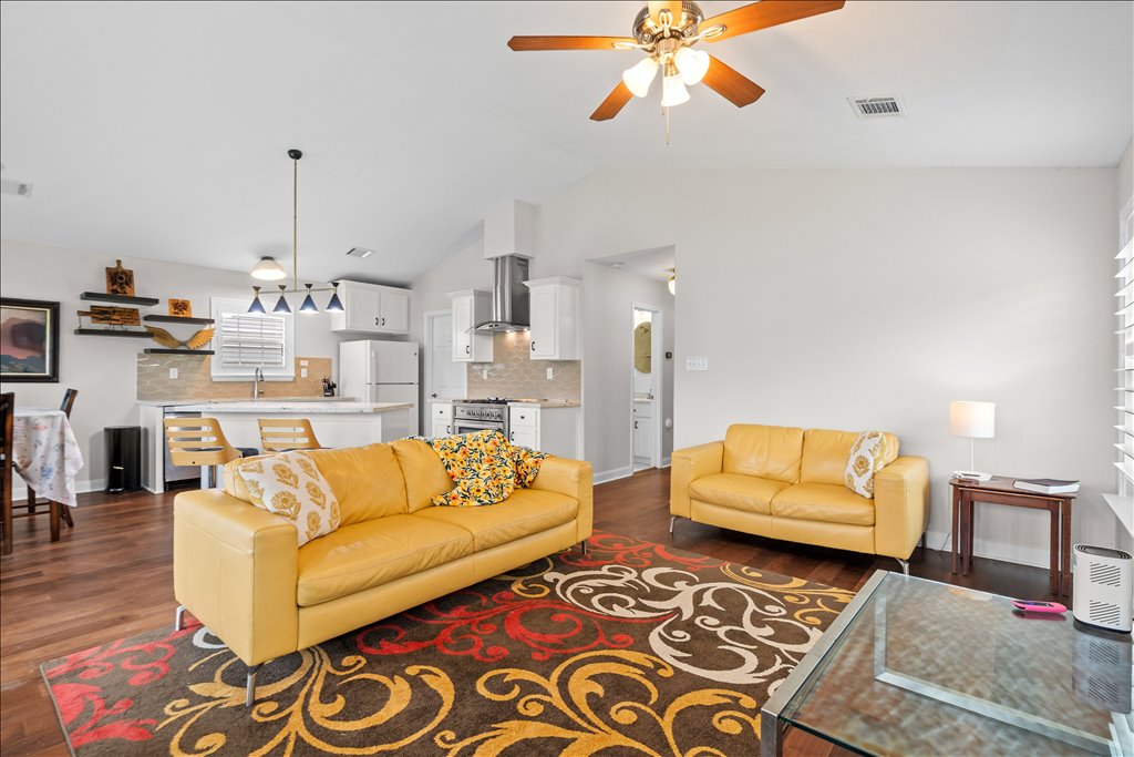 608 Whistleville Road Flatonia, TX 78941 - Photo 26 of 26 Notice the vaulted ceilings and how bright and airy the whole space feels. The warm flooring runs straight through, making the entire floor plan feel incredibly cohesive.