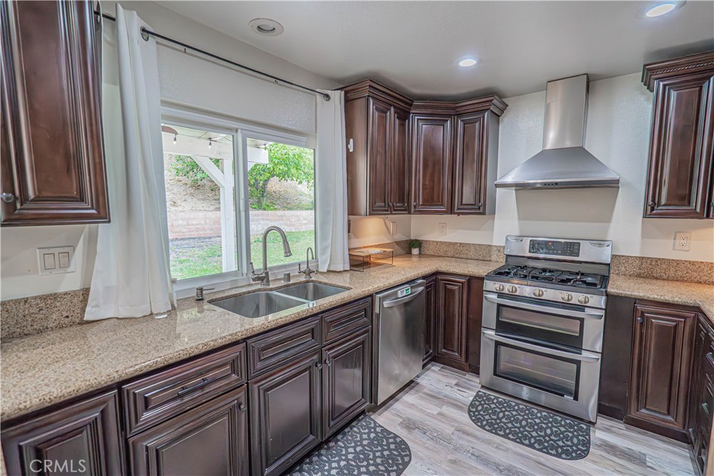 25535 Chisom Lane Stevenson Ranch, CA 91381 - Photo 14 of 37 a kitchen with granite countertop a sink a counter space appliances and cabinets