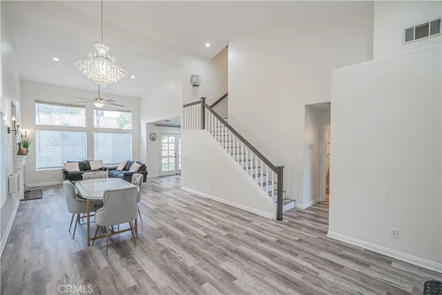 a dining room with wooden floor a chandelier a wooden table and chairs