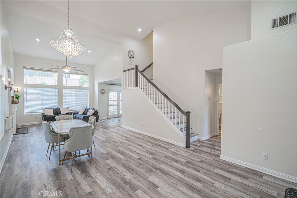 25535 Chisom Lane Stevenson Ranch, CA 91381 - Photo 7 of 37 a dining room with wooden floor a chandelier a wooden table and chairs