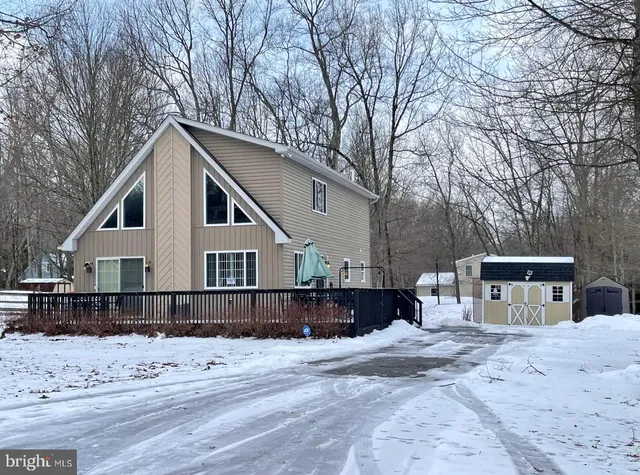 a front view of a house with a yard covered with snow in snow