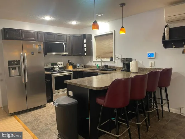 a kitchen with a table chairs refrigerator and microwave