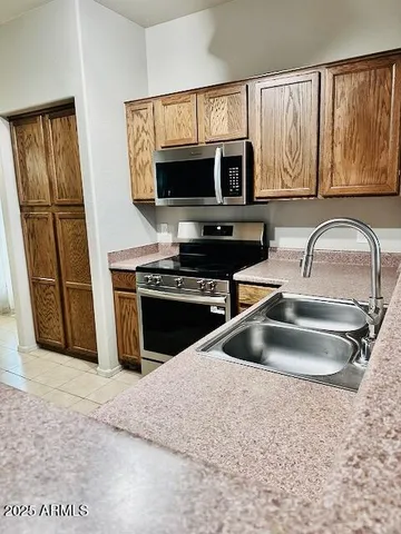 a kitchen with stainless steel appliances granite countertop a sink microwave and refrigerator