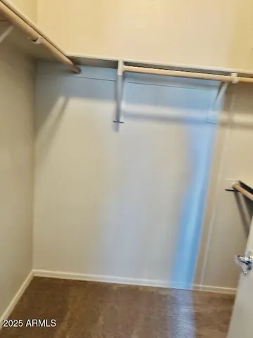 a view of an empty room with chandelier fan and fire place