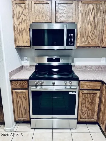 a kitchen with stainless steel appliances granite countertop a stove top oven microwave and cabinets