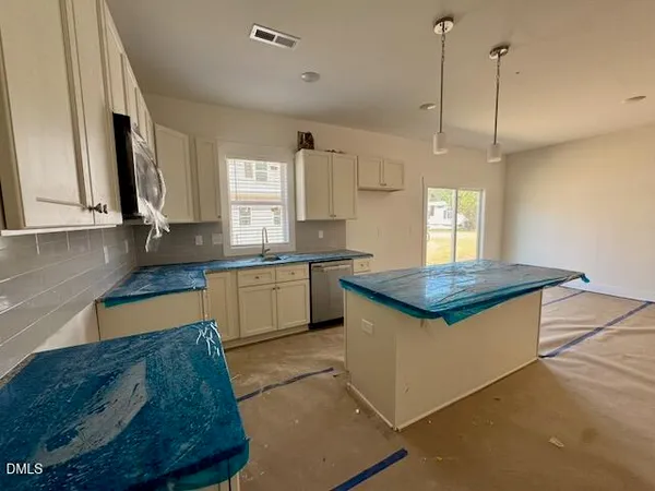 a kitchen with kitchen island granite countertop a sink appliances cabinets and a counter top space