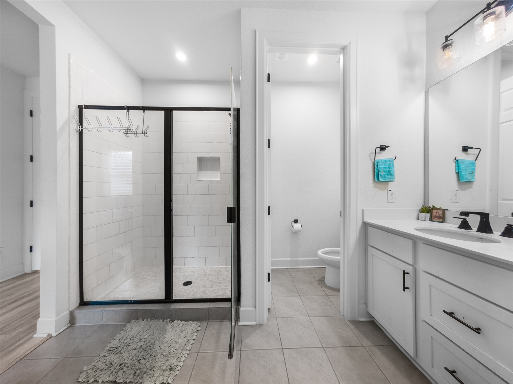 20811 Phebe Foster Street Manor, TX 78653 - Photo 20 of 40 Bathroom with vanity, light tile patterned floors, and a shower stall
