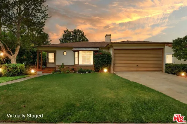 a front view of a house with a garden and yard