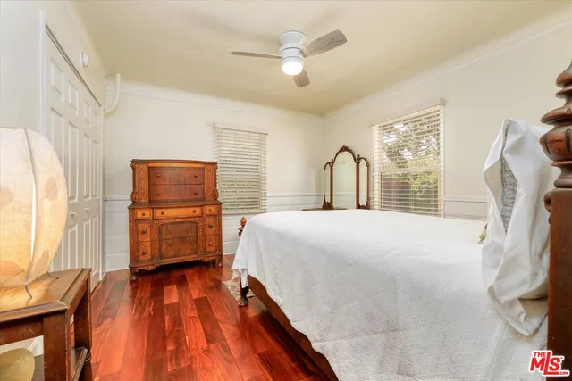 a bedroom with a bed dresser and a large window