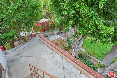 a view of a backyard with table and chairs potted plants