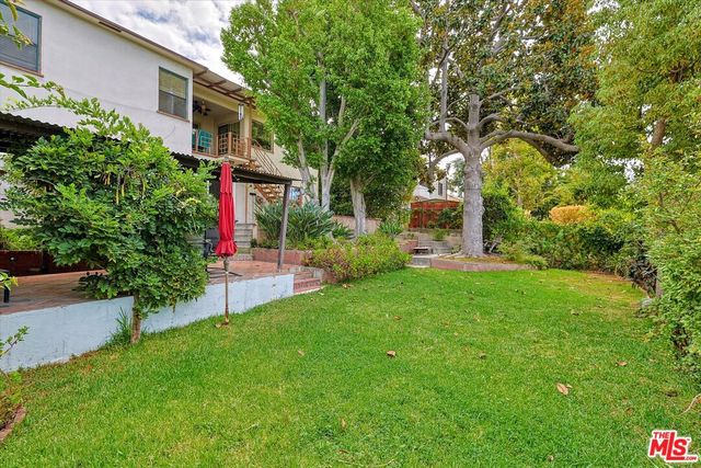 a front view of house with a garden