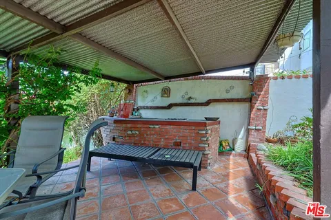 a view of a patio with table and chairs under an umbrella