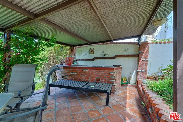 a view of a patio with table and chairs under an umbrella