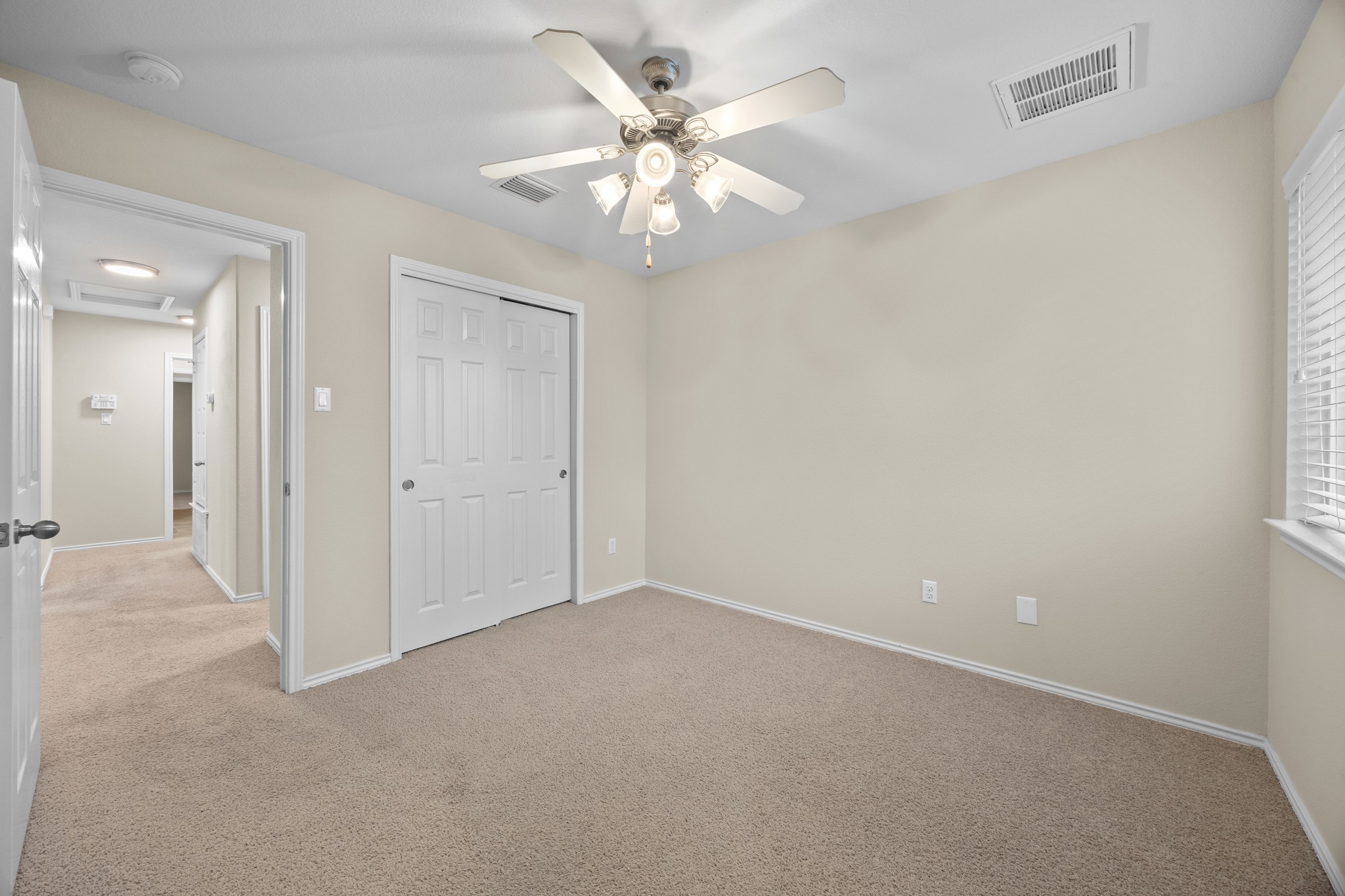 418 Nottingham Loop Kyle, TX 78640 - Photo 15 of 28 Bedroom featuring neutral carpeting, a ceiling fan with integrated lighting, a double-door closet, and a window with blinds