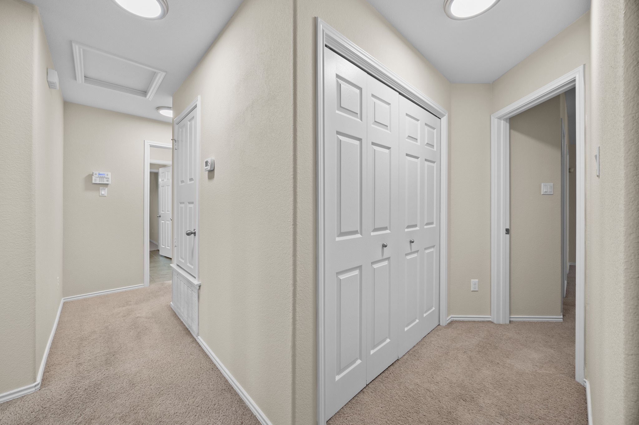 418 Nottingham Loop Kyle, TX 78640 - Photo 16 of 28 Interior hallway featuring neutral wall paint, light-colored carpeting, white trim, recessed lighting, and multiple paneled doors