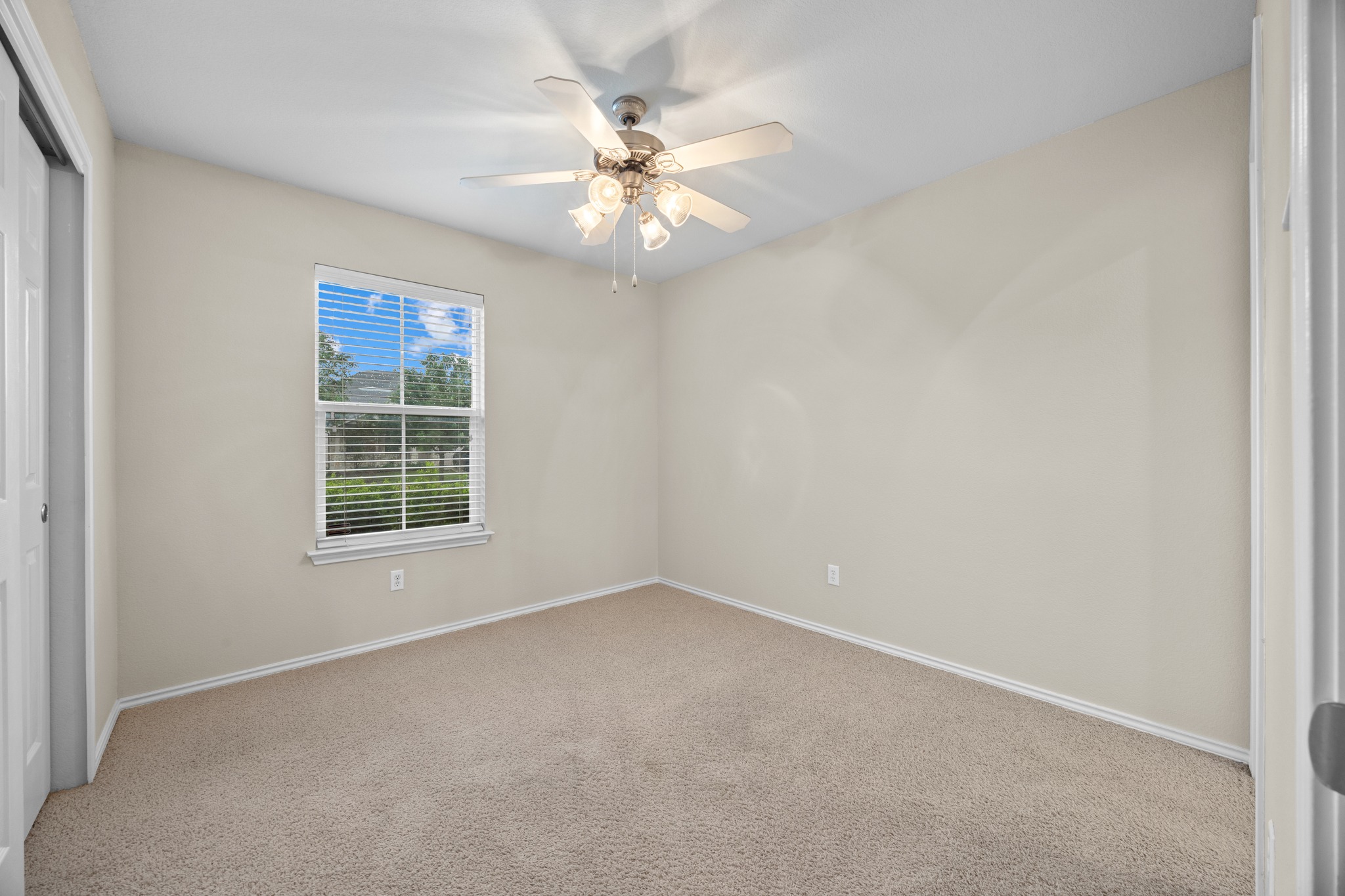 418 Nottingham Loop Kyle, TX 78640 - Photo 22 of 28 Neutral-toned room featuring a single window with blinds, a ceiling fan with integrated lighting, and wall-to-wall carpeting