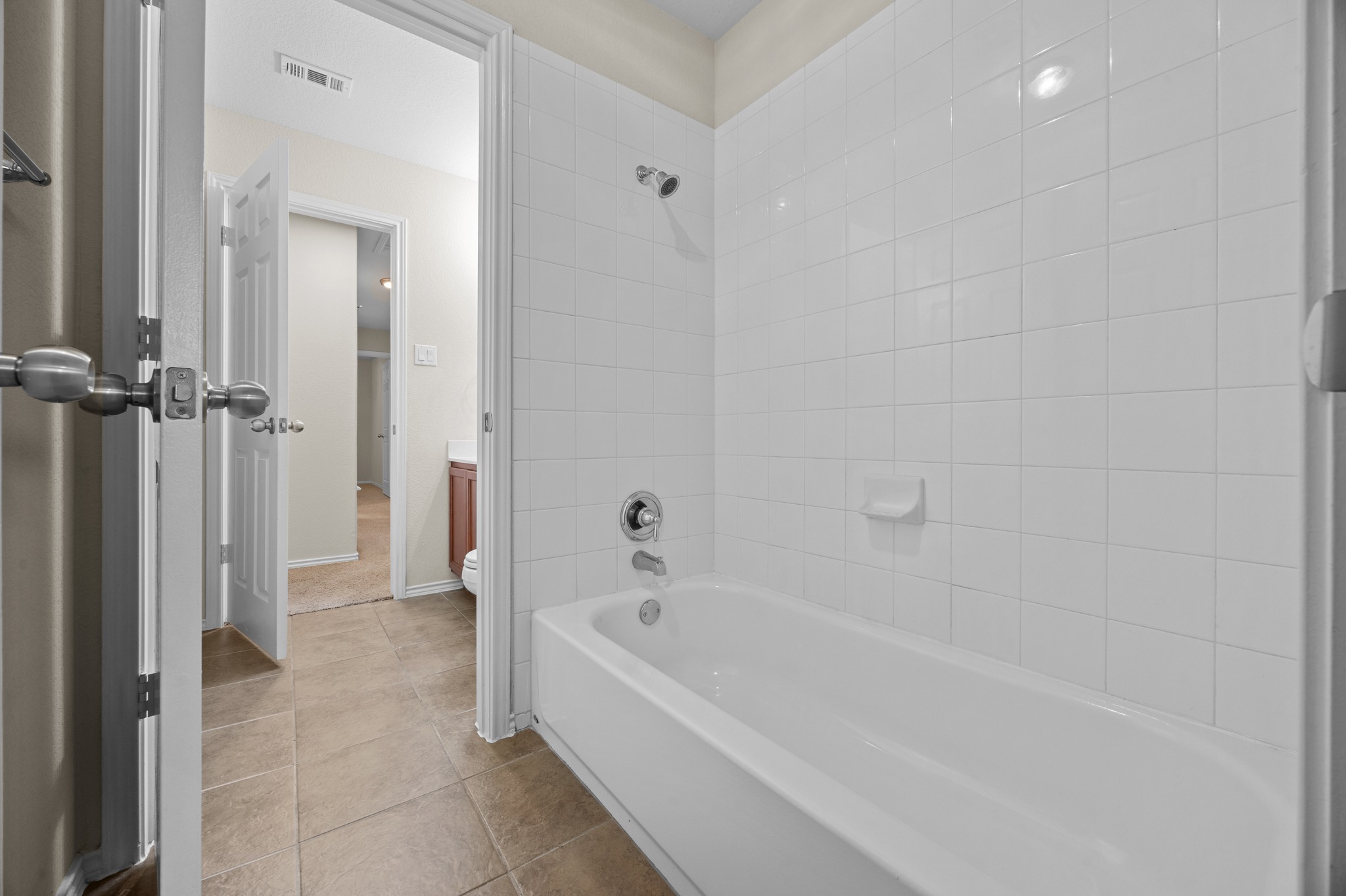 418 Nottingham Loop Kyle, TX 78640 - Photo 24 of 28 Bathtub with white subway tile surround, chrome fixtures, and a soap dish. Jack and Jill bathroom.