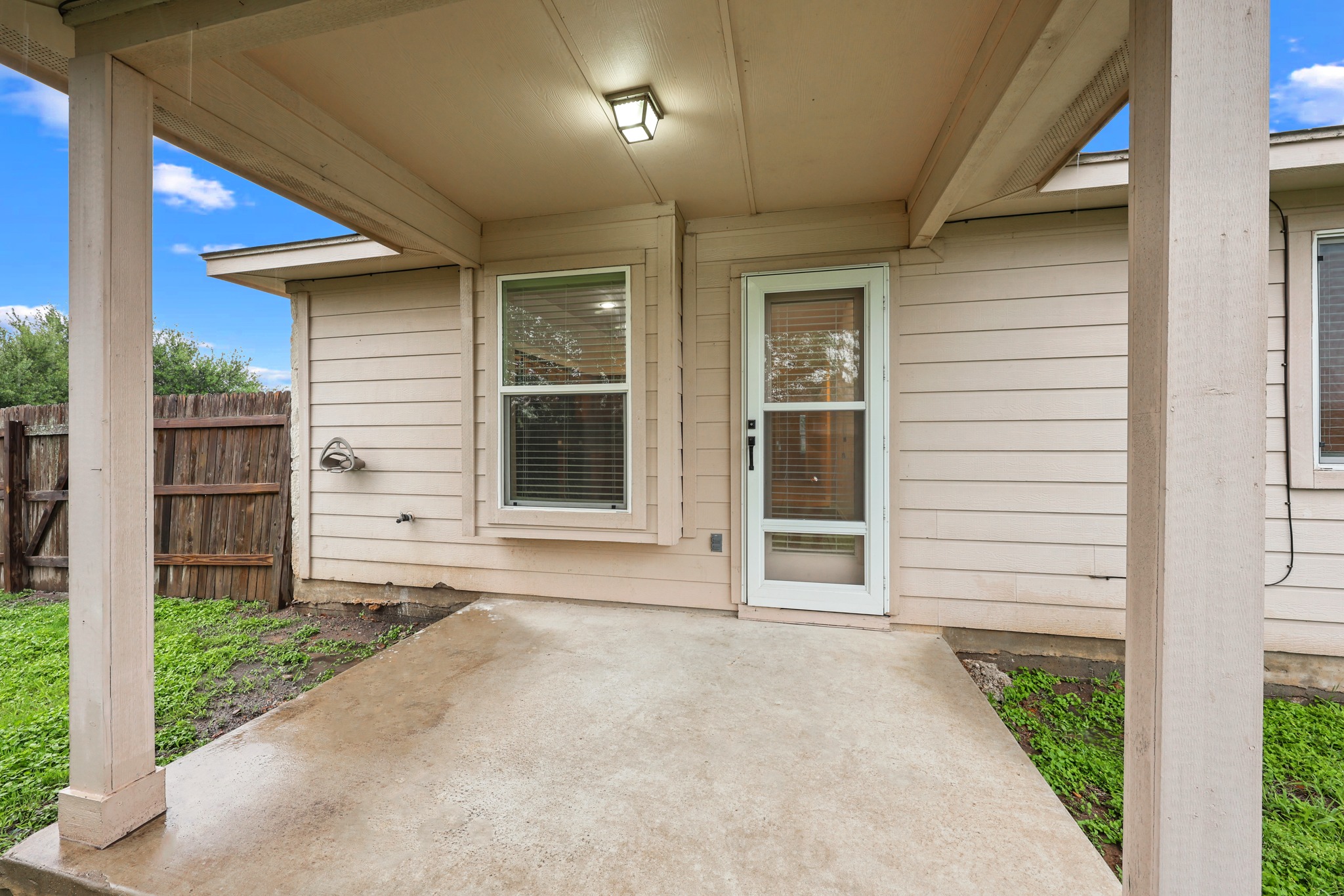 418 Nottingham Loop Kyle, TX 78640 - Photo 26 of 28 Covered patio with a concrete surface, featuring a security screen door, an exterior window, and horizontal siding