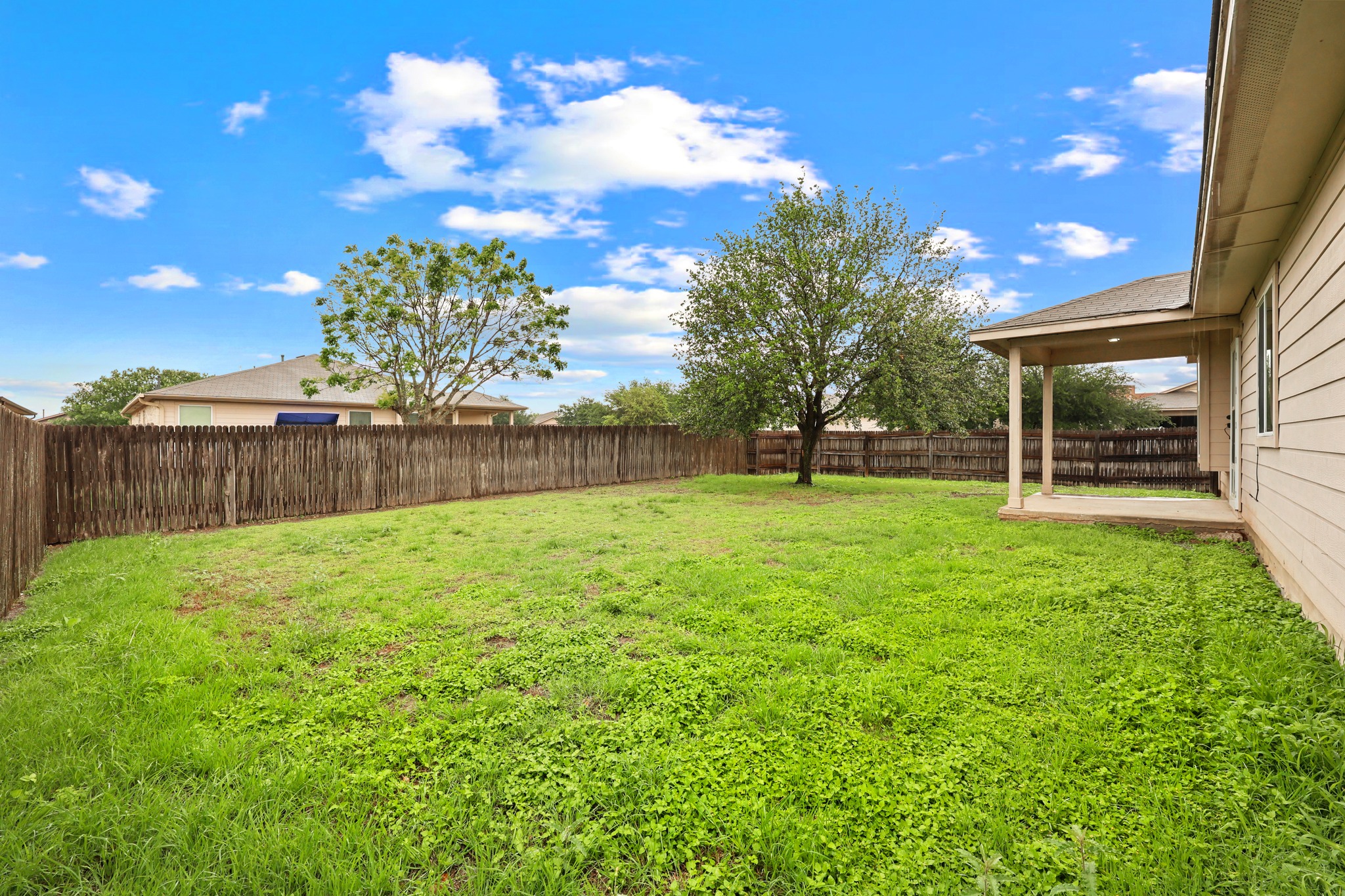 418 Nottingham Loop Kyle, TX 78640 - Photo 28 of 28 Expansive backyard featuring a mature tree, privacy fencing, and a covered patio