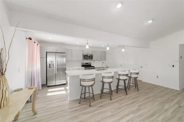 a kitchen with a white center island a table and chairs