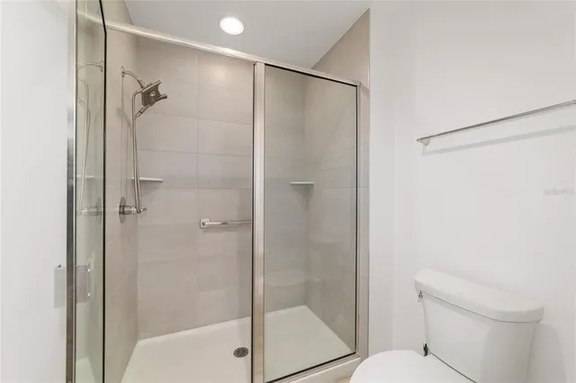 a spacious bathroom with a double vanity sink a large mirror and shower