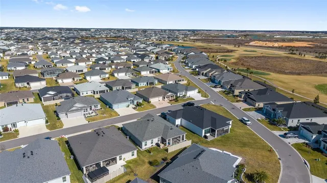 an aerial view of residential houses with outdoor space and swimming pool