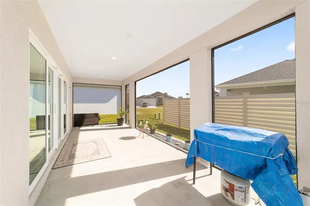 a bedroom with a bed and large windows