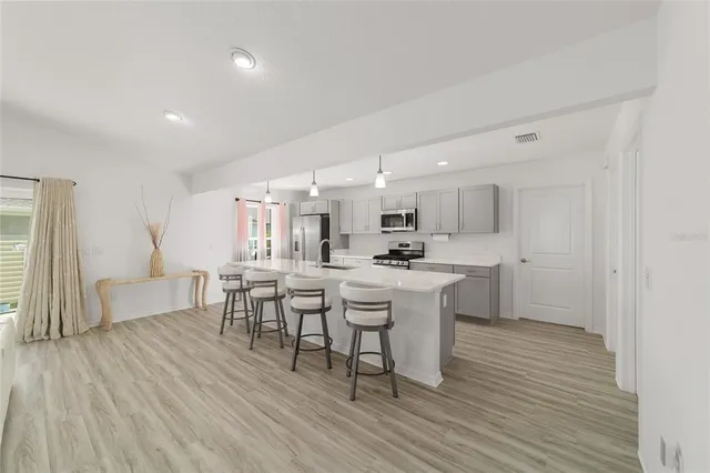 a large kitchen with a table and chairs