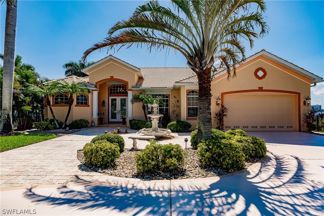 5727 Riverside Drive Cape Coral, FL 33904 - Photo 2 of 35 a front view of a house with garden