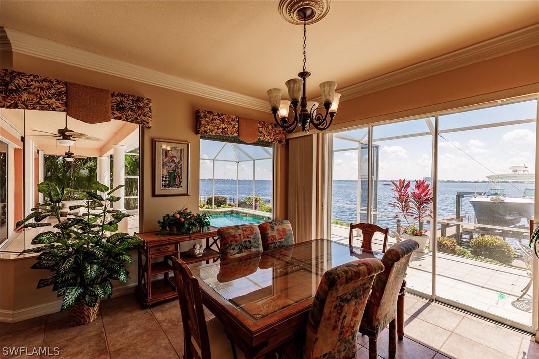 5727 Riverside Drive Cape Coral, FL 33904 - Photo 8 of 35 a view of a dining room with furniture large windows and a chandelier