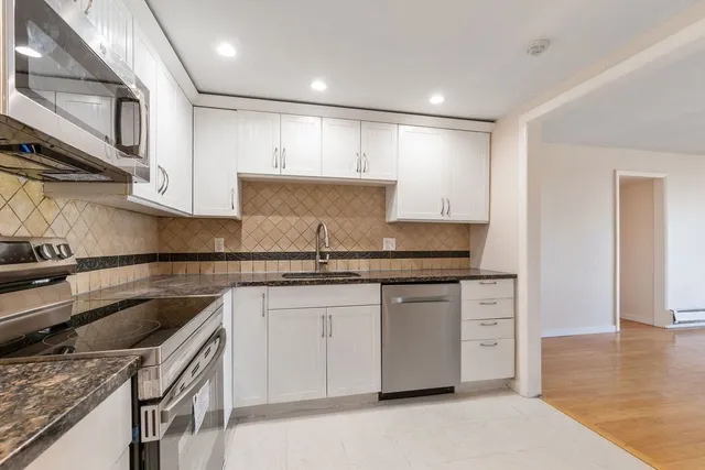 a kitchen with granite countertop a sink and cabinets