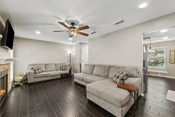 a living room with furniture and a wooden floor