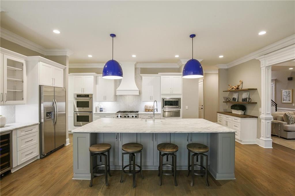 a kitchen with granite countertop a table chairs stainless steel appliances and wooden floor