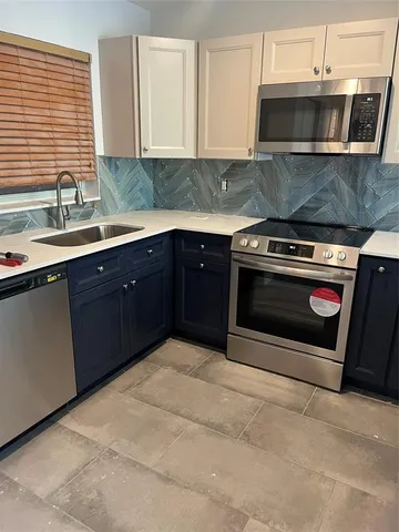 a kitchen with cabinets and stainless steel appliances