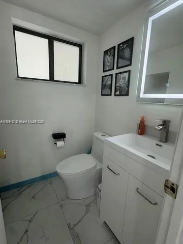 a bathroom with a toilet sink and mirror