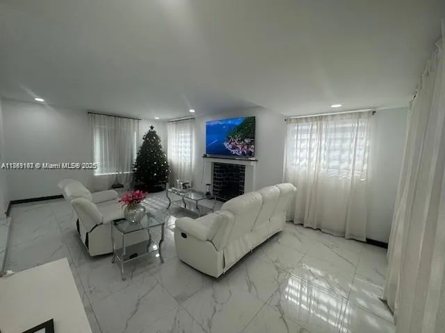 a living room with furniture a fireplace and a flat screen tv