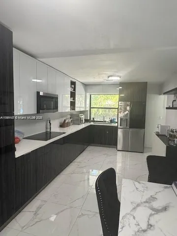 a large kitchen with a refrigerator and a stove top oven