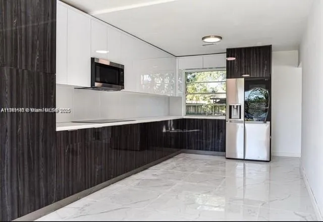 a kitchen with stainless steel appliances a refrigerator and a microwave
