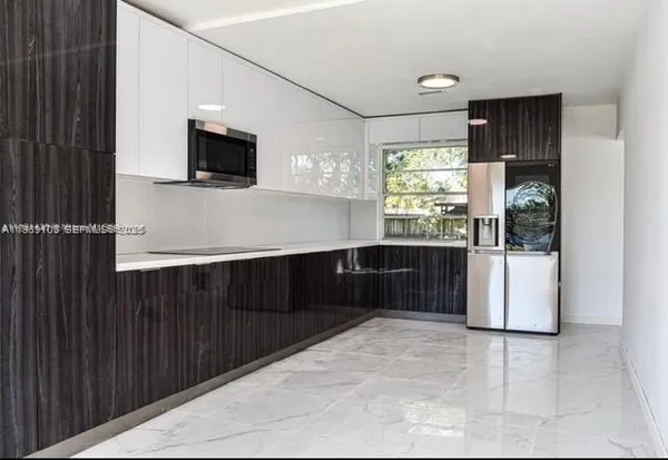 a kitchen with stainless steel appliances a refrigerator and a microwave