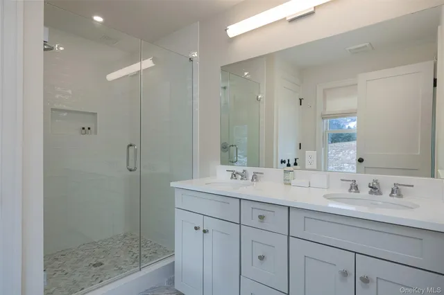 a bathroom with double sink and a mirror