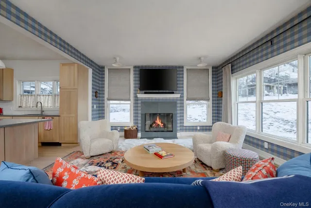 a living room with furniture fireplace and a large window
