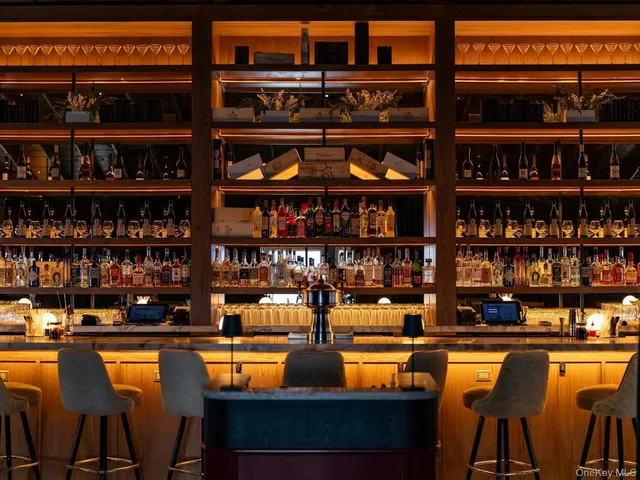 a table with wine bottles and a table in a bookshelf