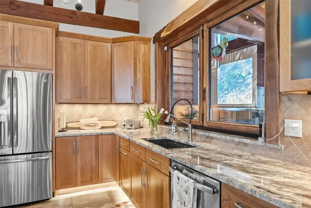 a kitchen with stainless steel appliances granite countertop a sink and a refrigerator
