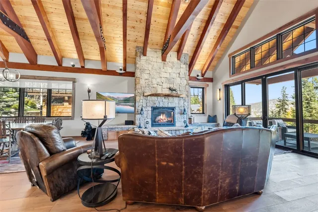 a living room with furniture a fireplace and large windows