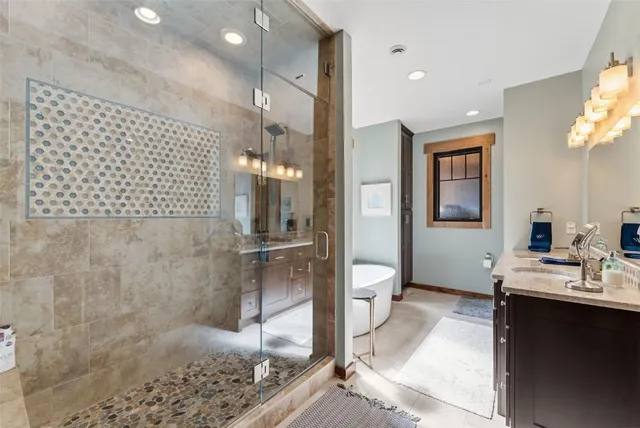 a bathroom with a double vanity sink toilet and shower
