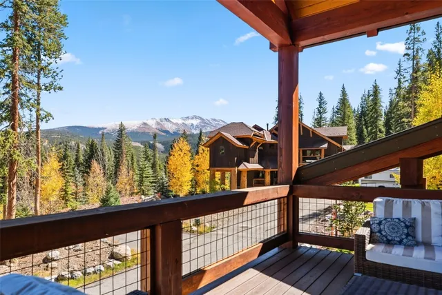 a view of a balcony with wooden floor and iron fence