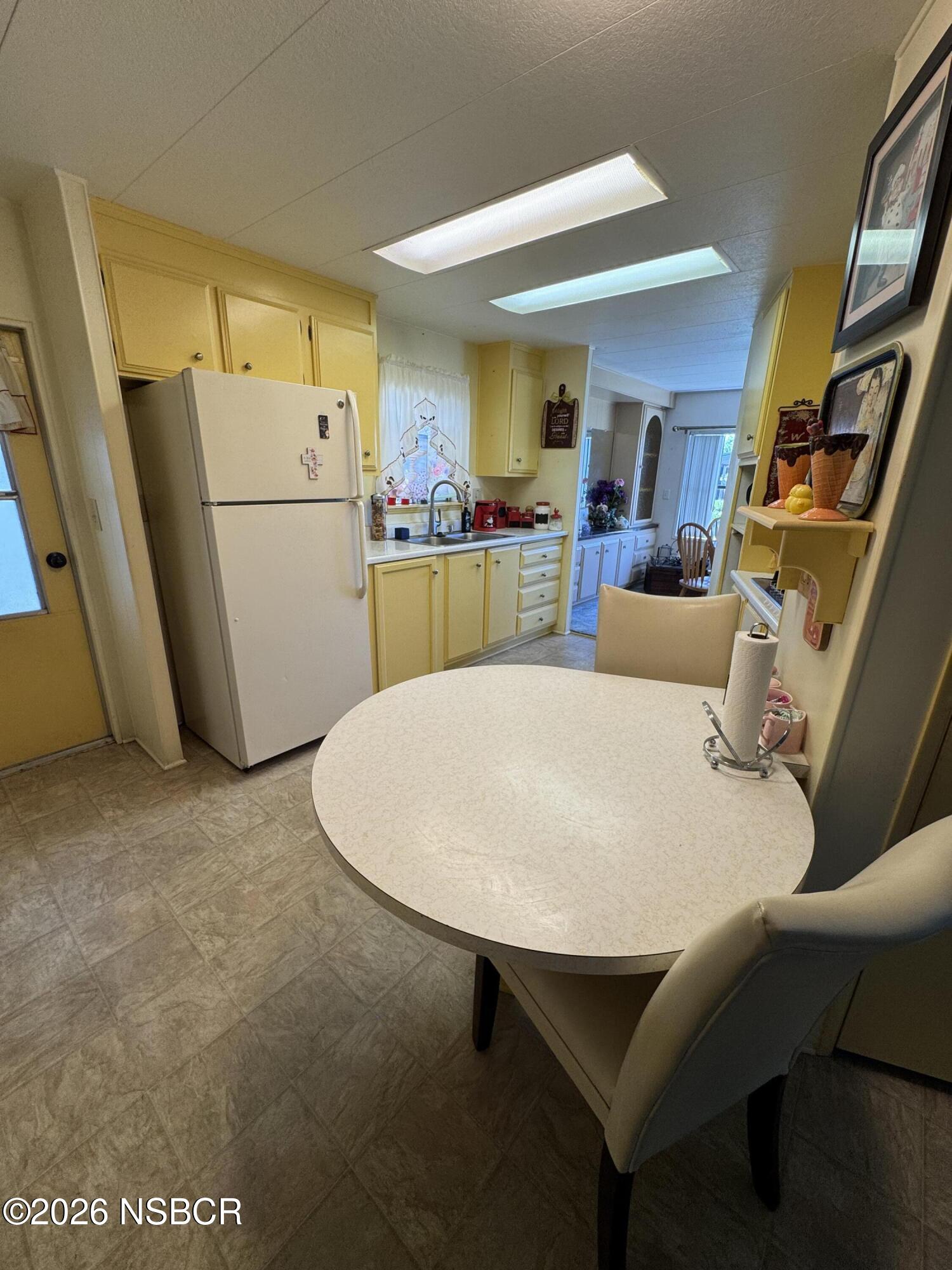 3210 Santa Maria Way, Unit 173 Santa Maria, CA 93455 - Photo 6 of 24 a living room with white furniture and a refrigerator