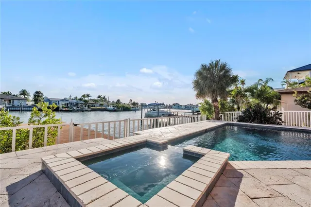 a kitchen with stainless steel appliances granite countertop a refrigerator a sink dishwasher a dining table and chairs with wooden floor